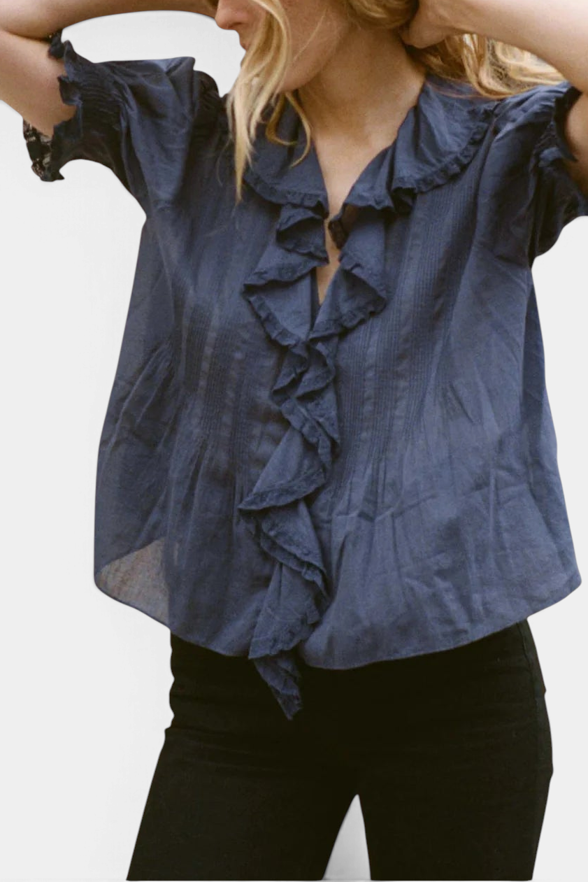 The Copper Shed Henri top in blue organic cotton voile with a ruffled V-neckline and puffed sleeves.