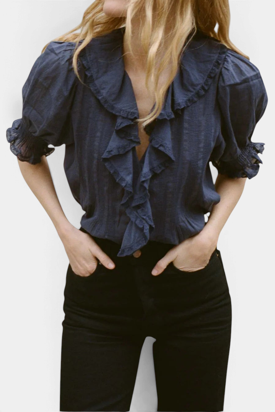 The Copper Shed Henri Top in navy organic cotton voile with a V-neck, lace-trimmed ruffles, and puffed sleeves.