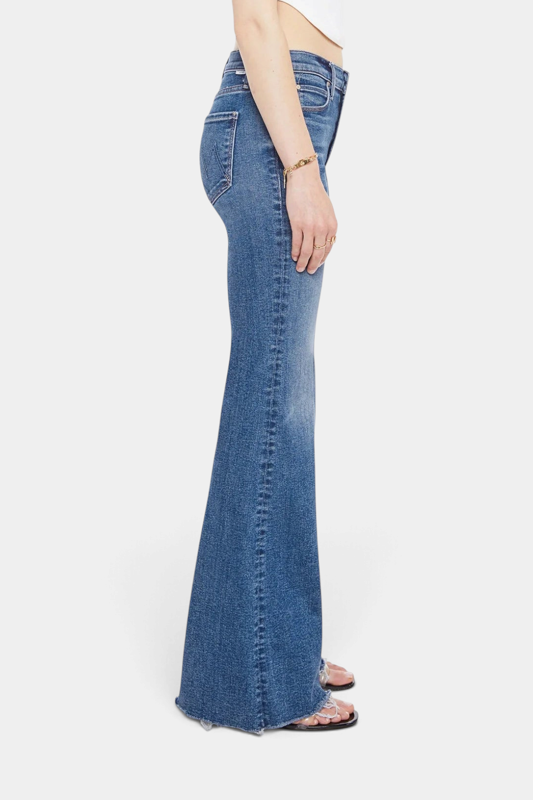 The Copper Shed The Doozy Sneak Fray high-rise flare jeans in mid-blue stretch denim with a frayed hem, side view.
