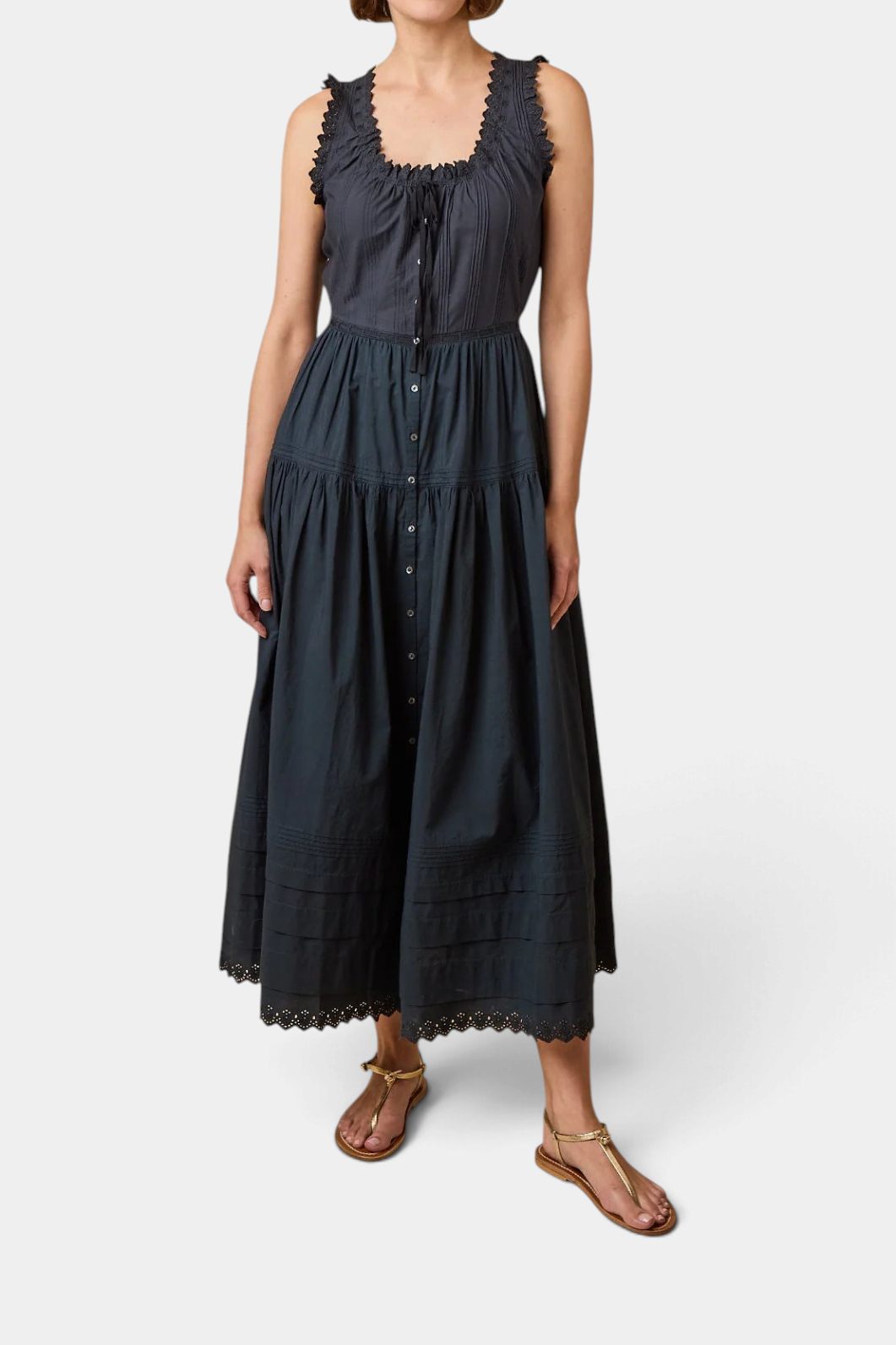 The Copper Shed Hortense dress in dark grey organic cotton with eyelet embroidery, pintucks, and a tiered skirt.