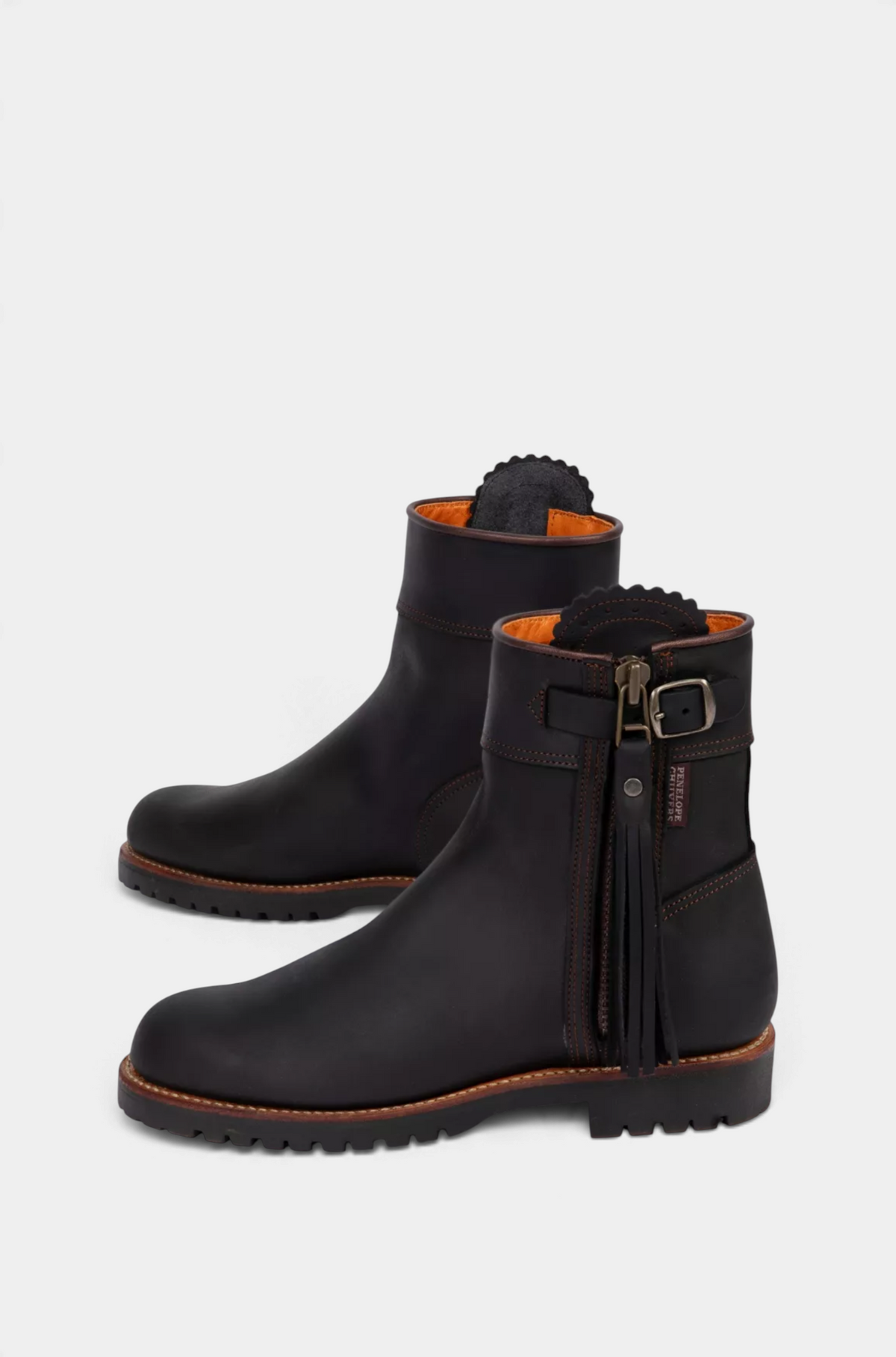 The Copper Shed Inclement cropped waterproof suede boots in dark brown with side tassel, buckle, and lug sole.