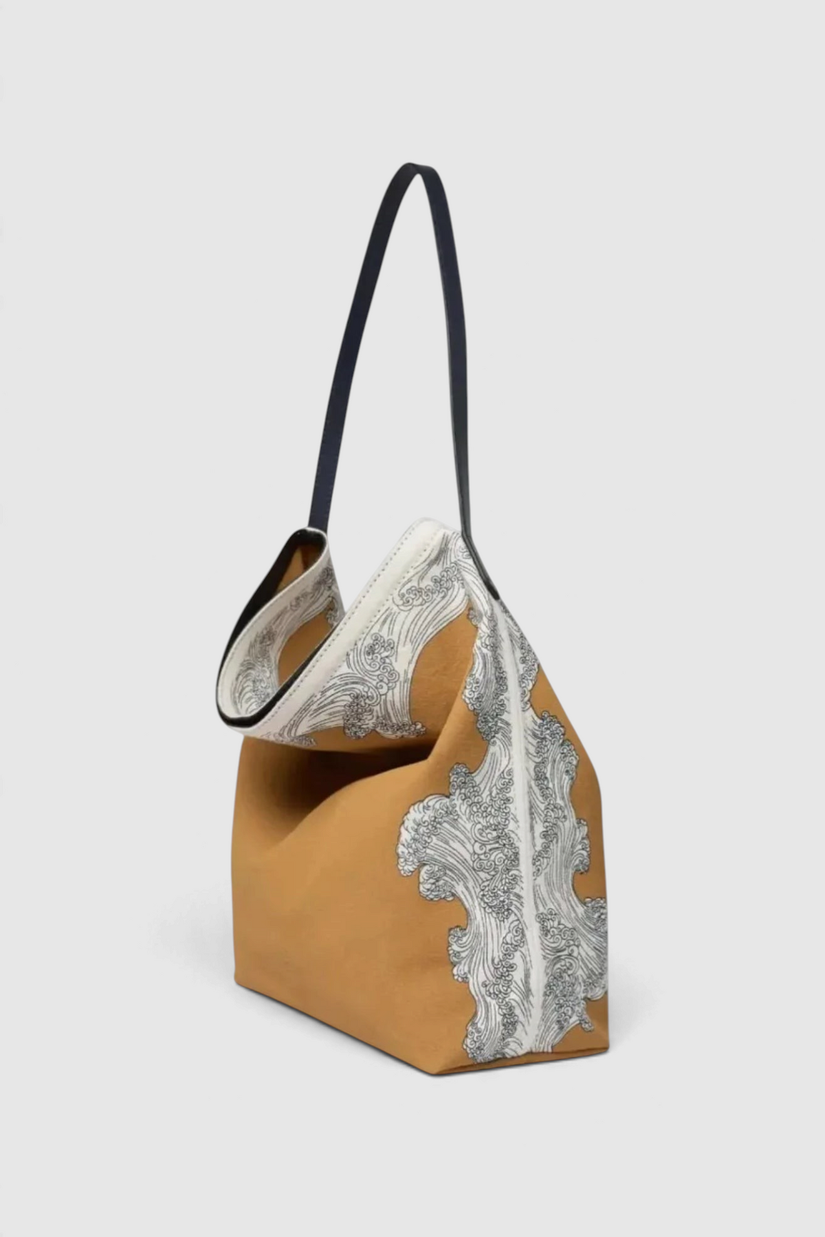 The Copper Shed Inoui Campus bag in tan cotton with a black leather handle and white wave print side panels.
