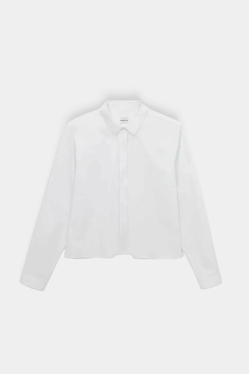 The Copper Shed Iris white cotton poplin long sleeve cropped shirt with a fly front placket and button cuffs.