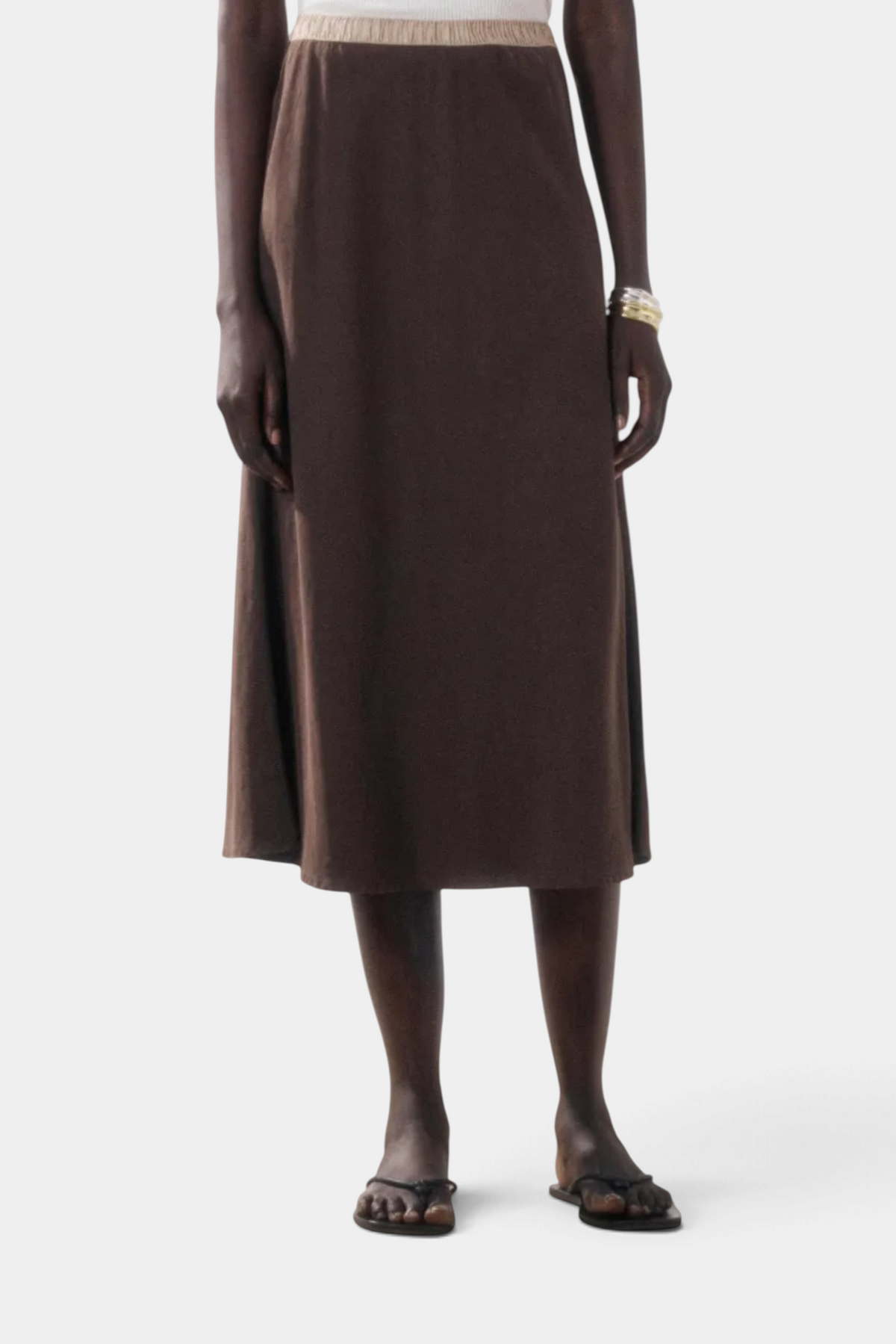 The Copper Shed Jima midi skirt in brown lyocell with a bias cut and a metallic lurex elastic waistband.