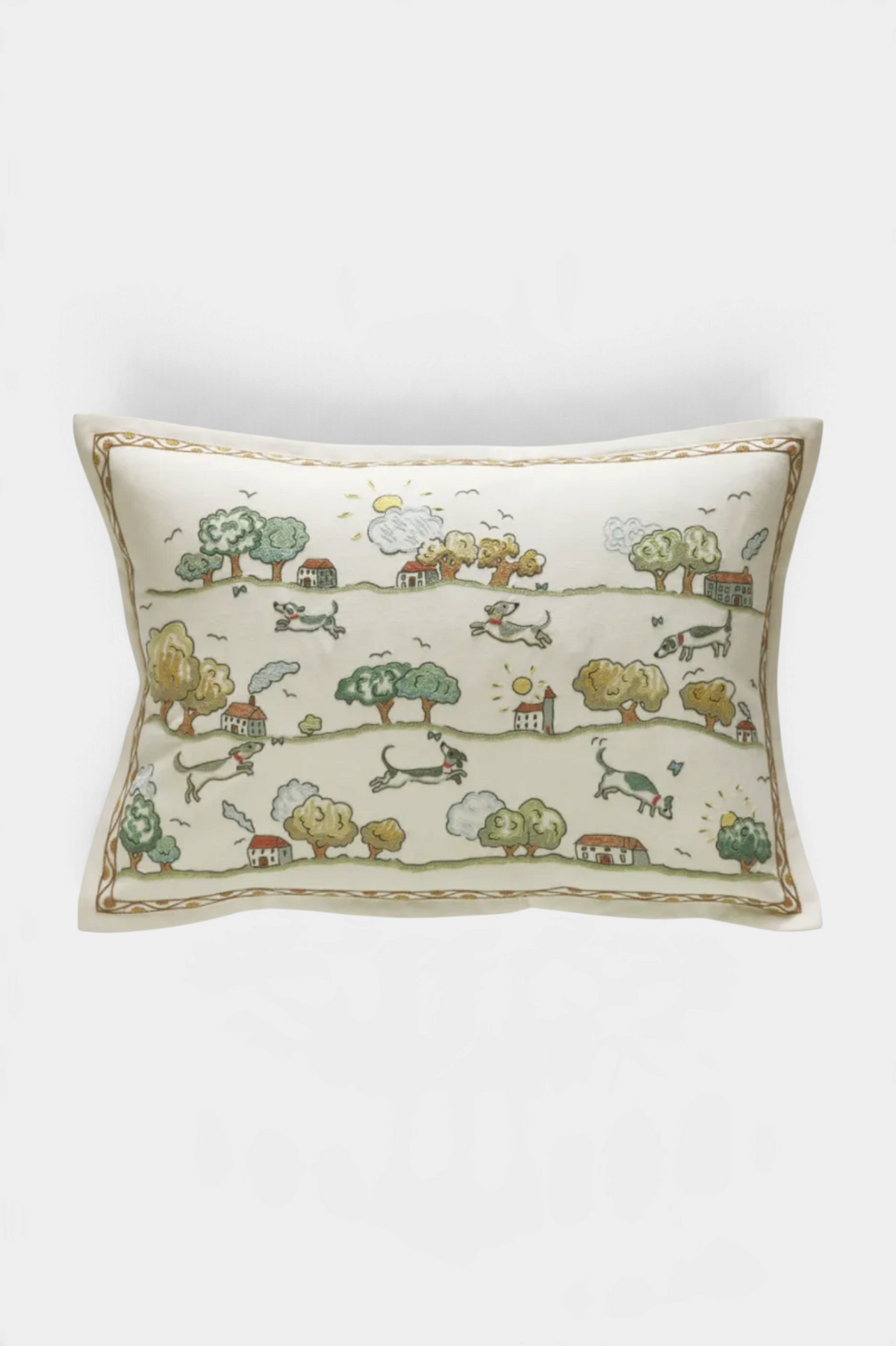 The Copper Shed Jumping Over Houses cushion featuring hand-embroidered dogs and landscape on a linen-cotton blend.