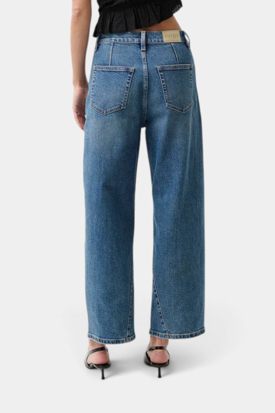 The Copper Shed Kyra high rise bowed ankle jeans in a light vintage wash with back yoke seam detail, rear view.