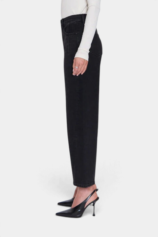 The Copper Shed Kyra high rise bowed ankle jeans in a black wash, shown from the side with a white top and heels.