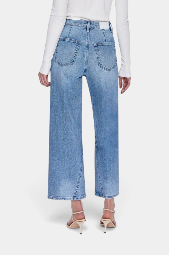 The Copper Shed Kyra high rise jeans in light wash denim featuring a bowed leg silhouette and back yoke seam detail.