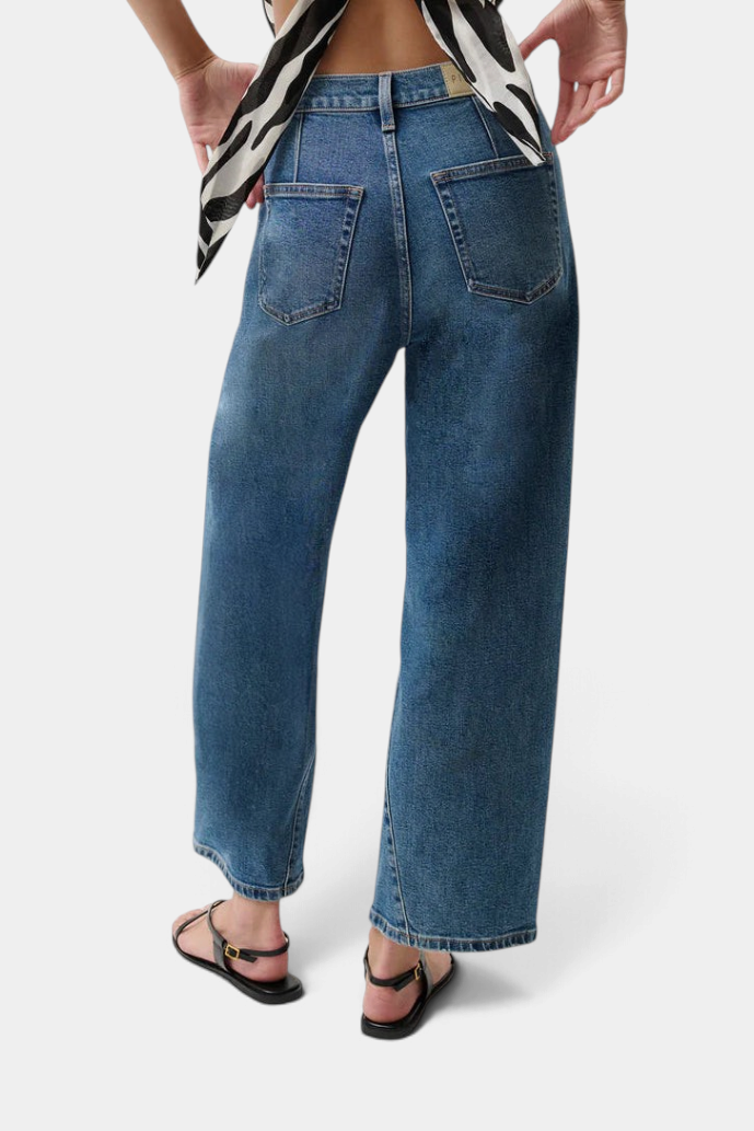 The Copper Shed Kyra high rise jeans in a light vintage wash with back yoke seams and a bowed leg silhouette