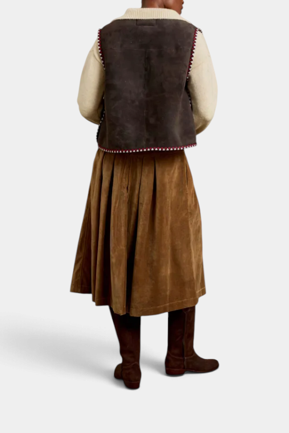 The Copper Shed Lancaster cotton velvet skirt in brown, worn with a sweater vest and tall boots, back view.