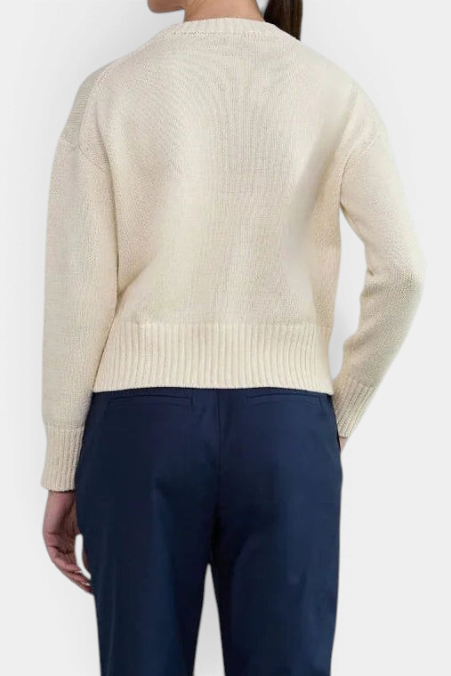 The Copper Shed Logan cotton crewneck sweater in cream with a high-low hem and wide ribbed cuffs, back view.