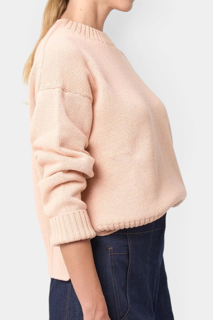 The Copper Shed Logan cotton crewneck sweater in pale pink with a relaxed fit, high-low hem, and wide ribbed cuffs.