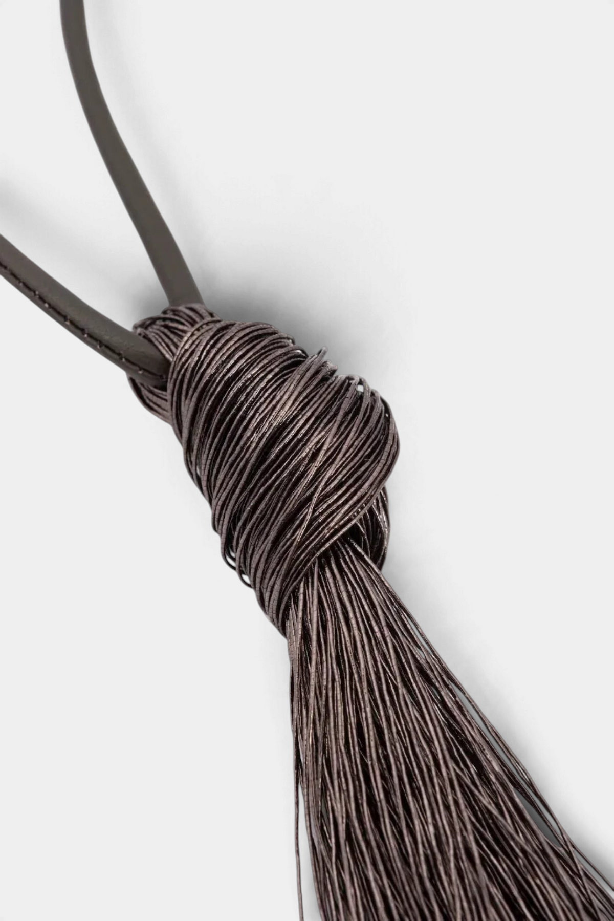 The Copper Shed long necklace featuring a dark brown viscose fringe pendant suspended from a smooth leather cord.