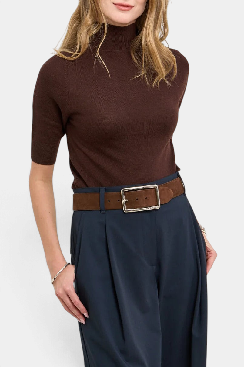 The Copper Shed Maddy sweater in brown merino wool with a mock neck and short sleeves, styled with navy trousers.