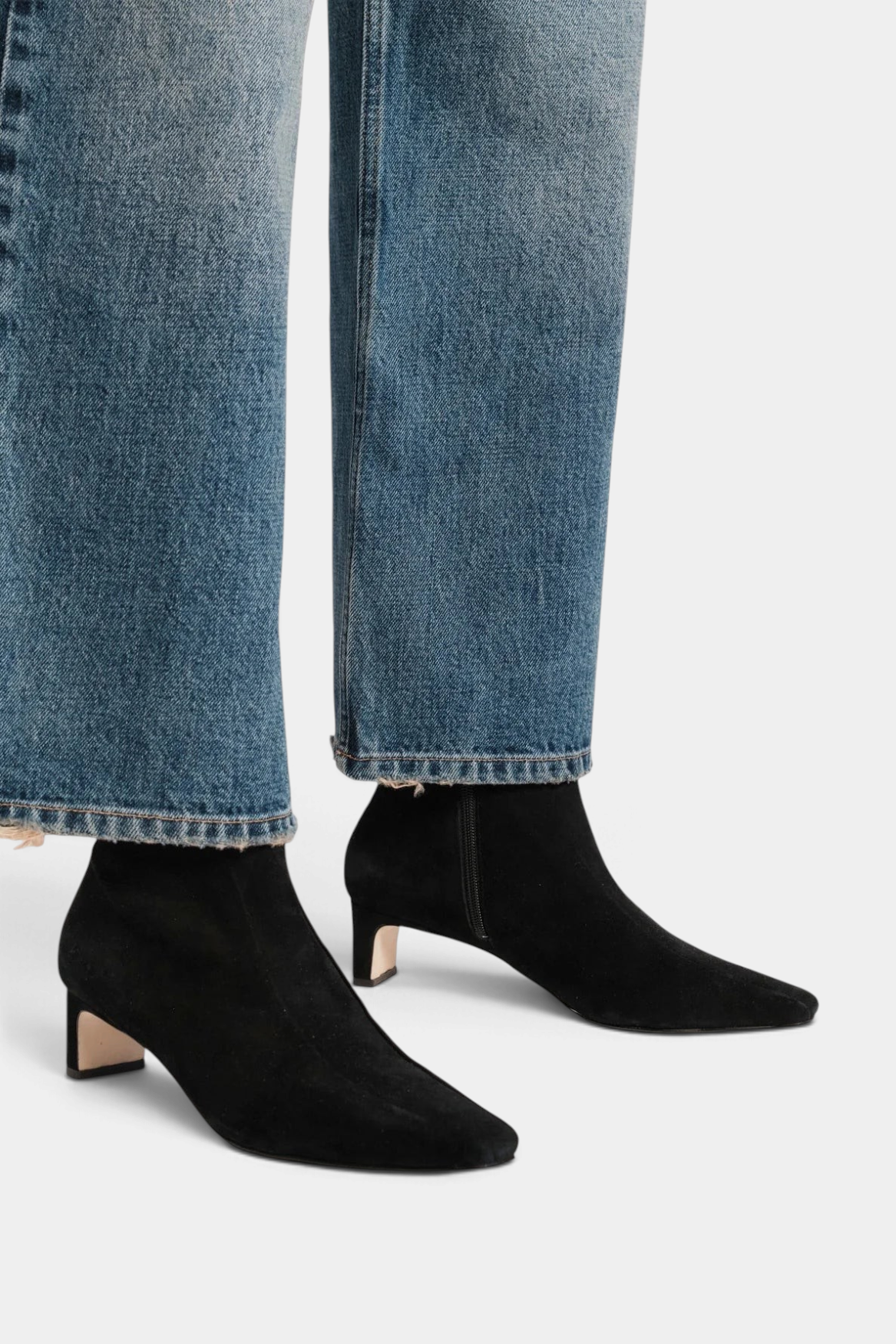 The Copper Shed Marianne black stretch suede ankle boots with a two-inch block heel worn with blue denim jeans.