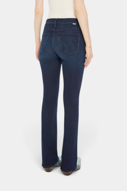 The Copper Shed mid-rise flared jeans in dark blue stretch denim with a clean hem, back view on a model.
