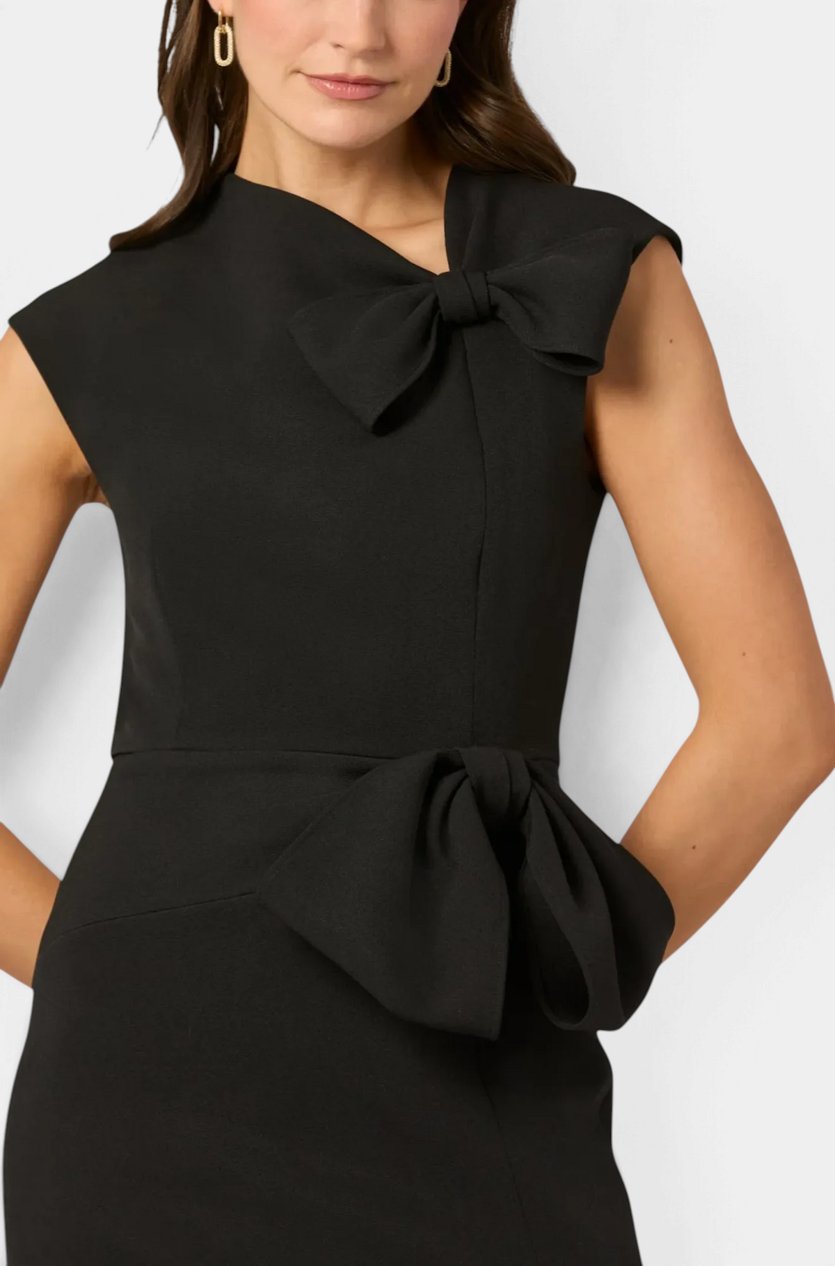 The Copper Shed Midnight Amor black stretch crepe gown with asymmetric neckline and bow details at neck and waist.