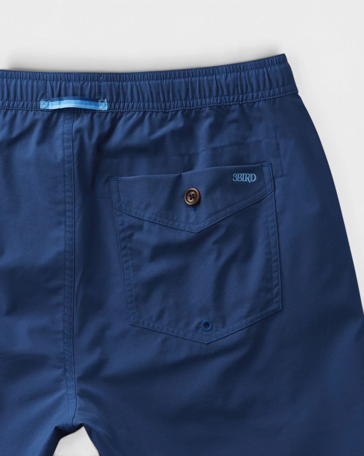 The Copper Shed Migration Drawcord short in navy blue featuring a rear welted pocket with a Corozo button closure.