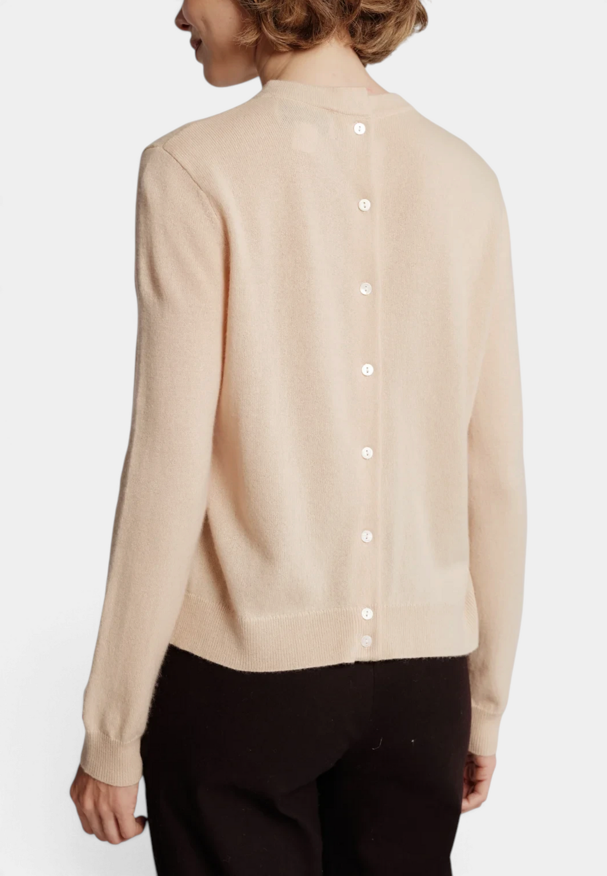 The Copper Shed Mila merino wool sweater in beige featuring a buttoned back with mother of pearl buttons.