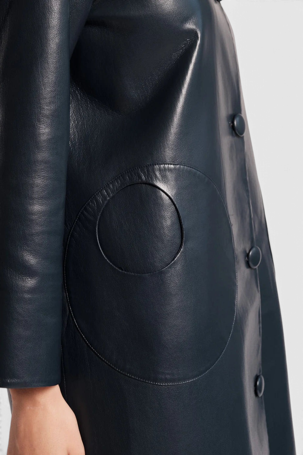 The Copper Shed Mod Jacket in navy faux leather featuring a round collar, covered buttons, and circular front pockets.