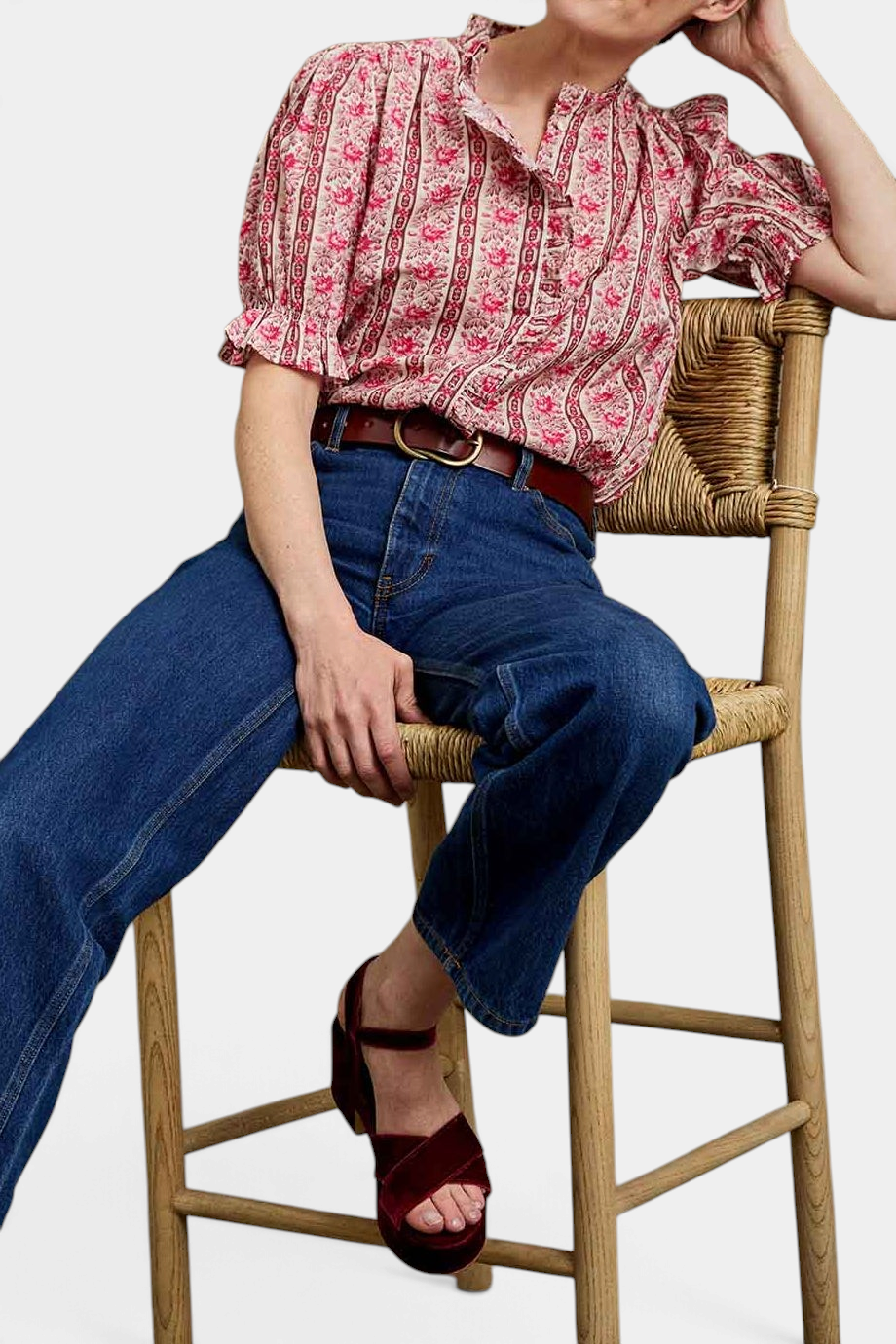 The Copper Shed Monday Prairie Blouse in pink floral cotton dobby with ruffled sleeves, worn with blue jeans.