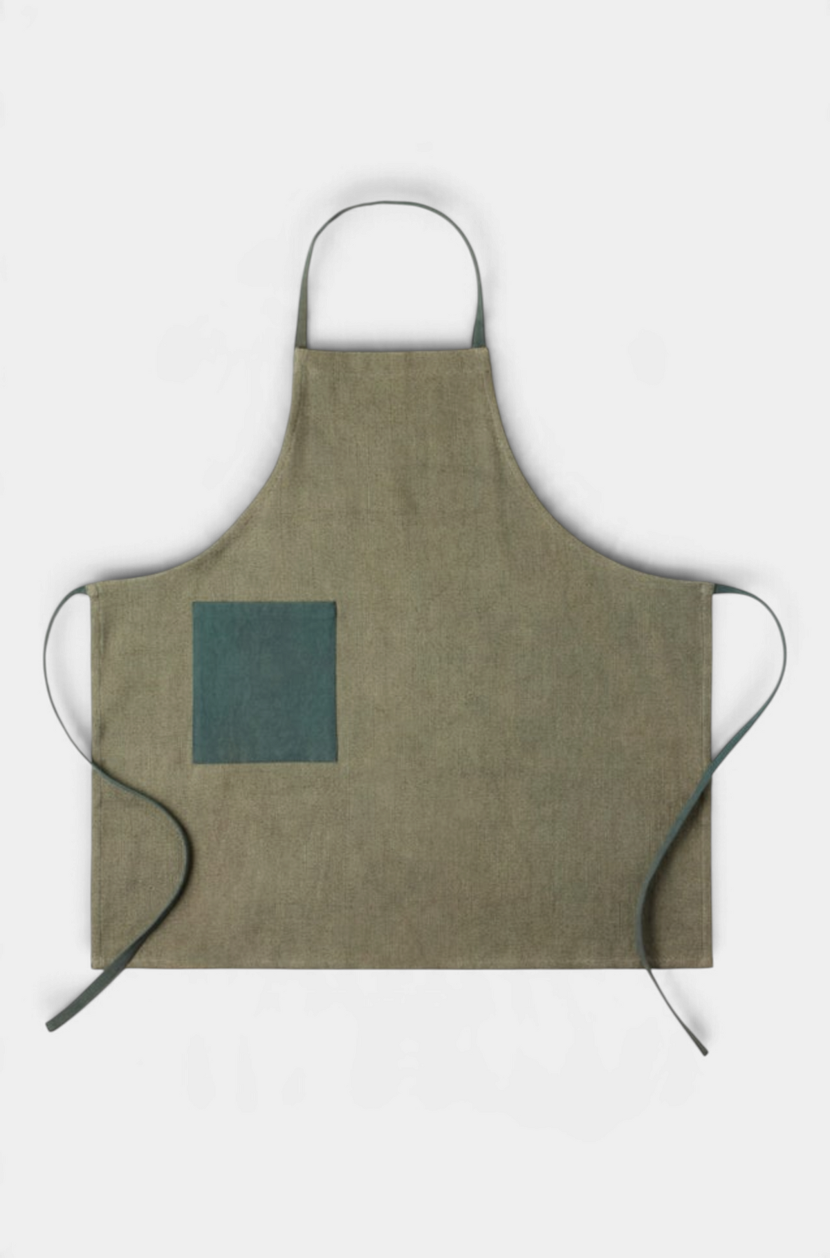 The Copper Shed Myra forest green and beige color-blocked cotton jute apron with a deep pocket and adjustable straps.