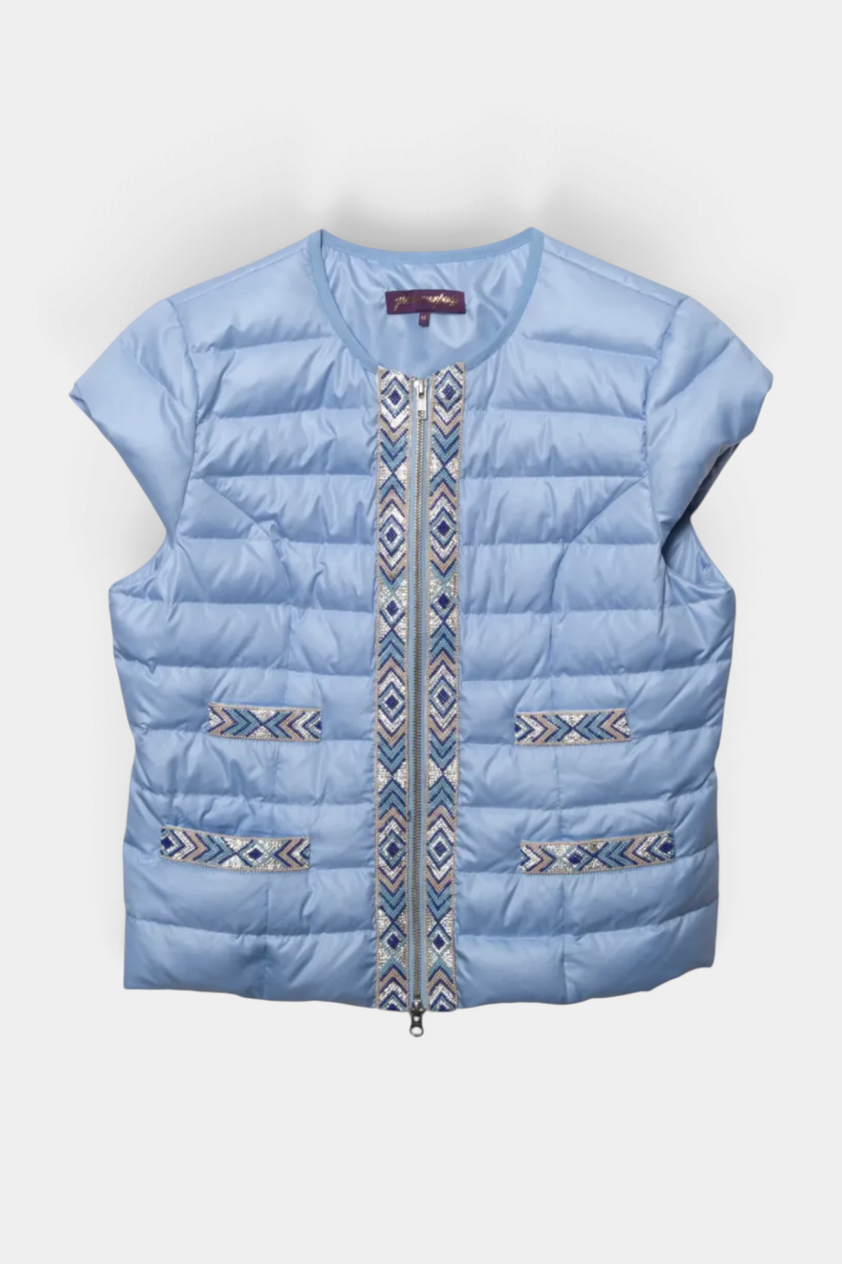 The Copper Shed light blue quilted vest with sparkly Navajo-inspired geometric trim and front zip closure.