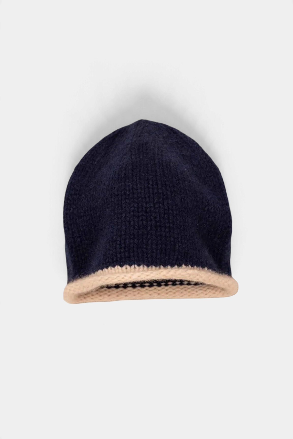 The Copper Shed navy blue organic cashmere beanie with a chunky hand-knitted texture and a contrasting beige rolled edge