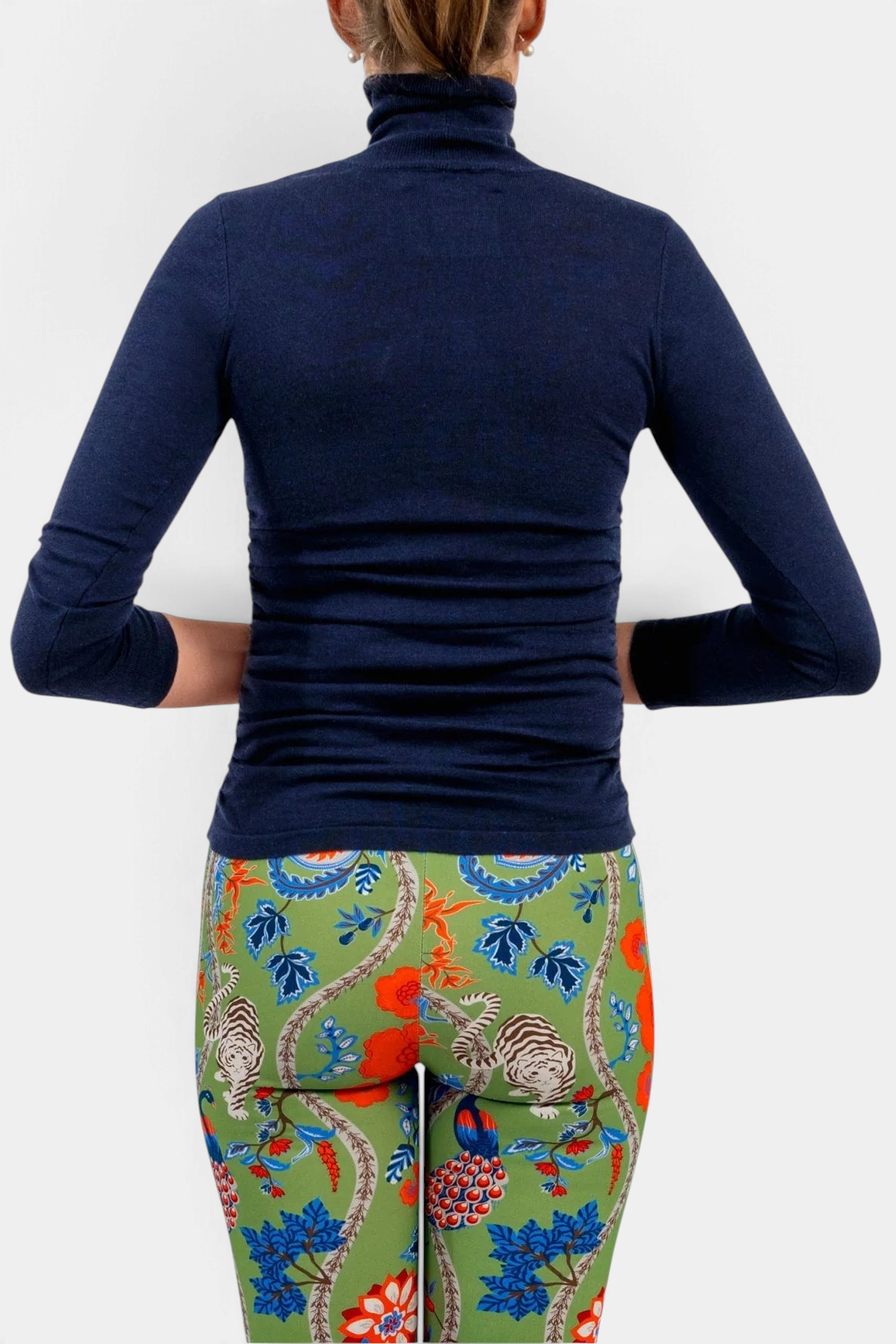 The Copper Shed navy blue cashmere turtleneck sweater worn with patterned green floral leggings, back view