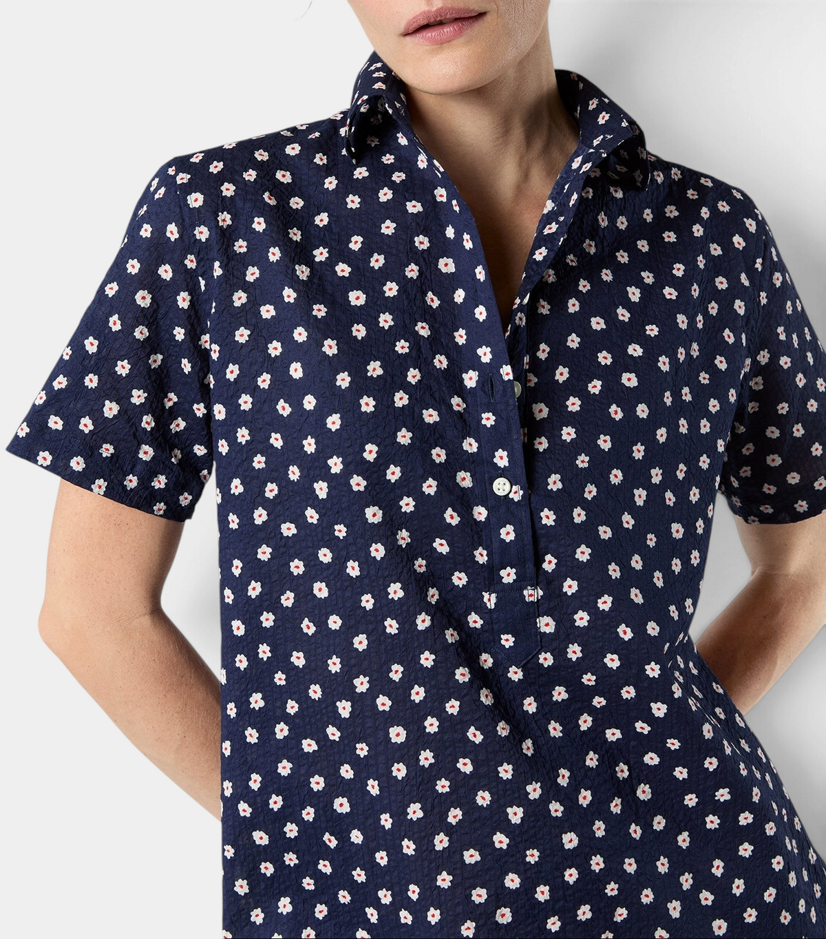 The Copper Shed short-sleeved popover dress in navy crinkle cotton with a white and red daisy floral print