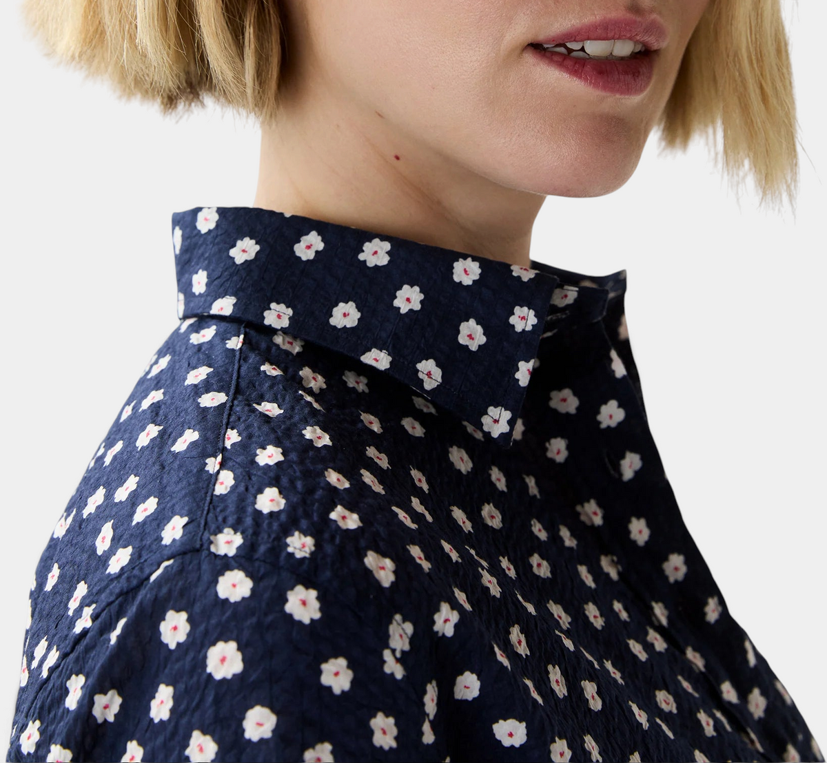 The Copper Shed short-sleeved popover dress in navy blue crinkle cotton with a white and red daisy floral print.
