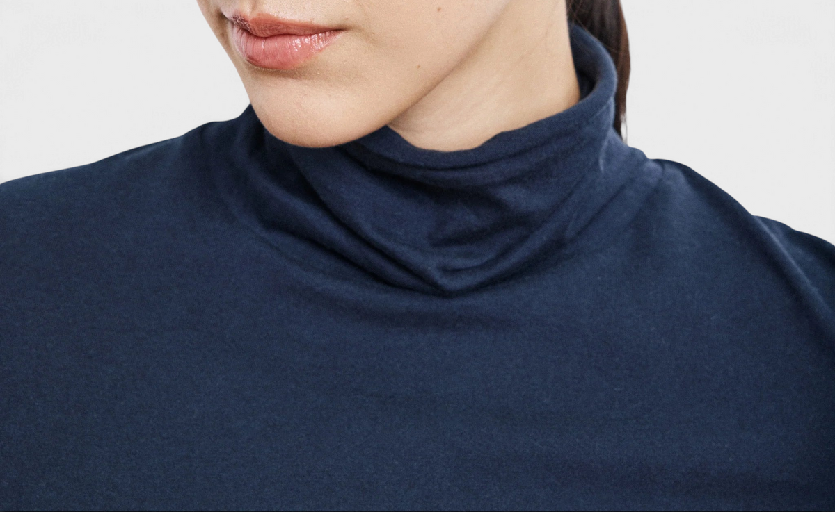 The Copper Shed navy blue long-sleeved knit T-shirt with a stand-up collar worn by a woman