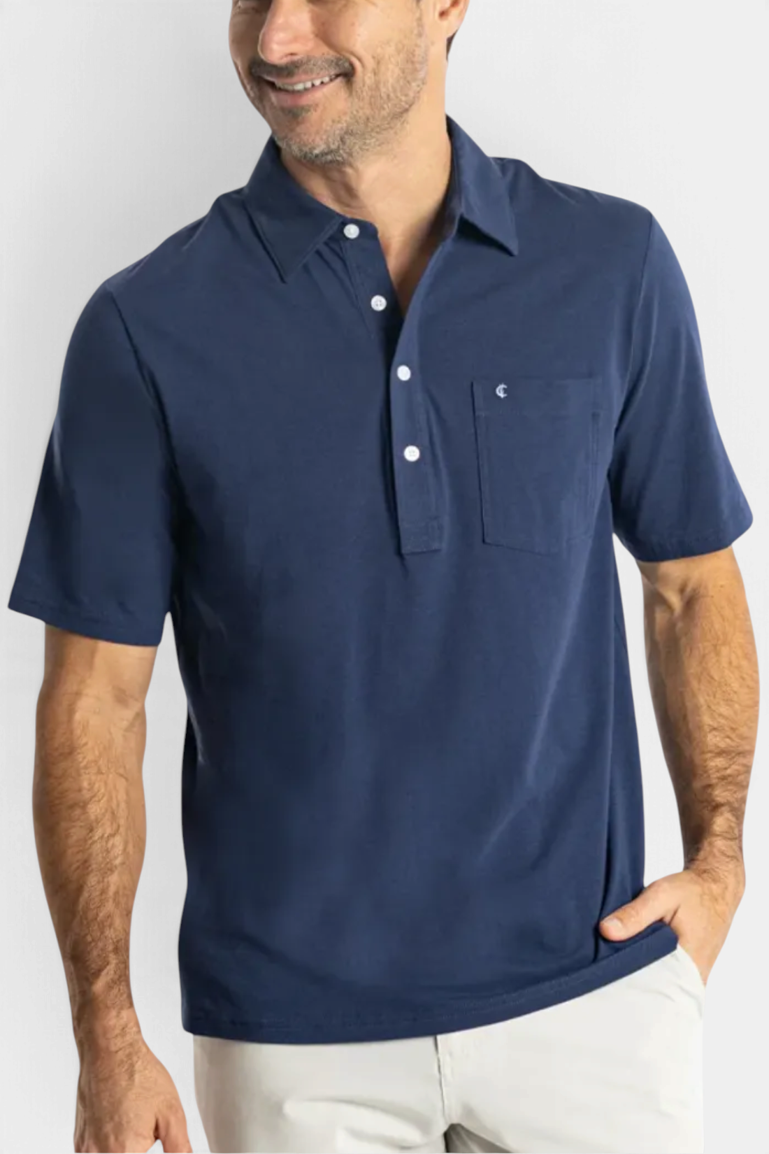 The Copper Shed navy blue Pima cotton polo shirt with a chest pocket and crisp collar on a smiling man.