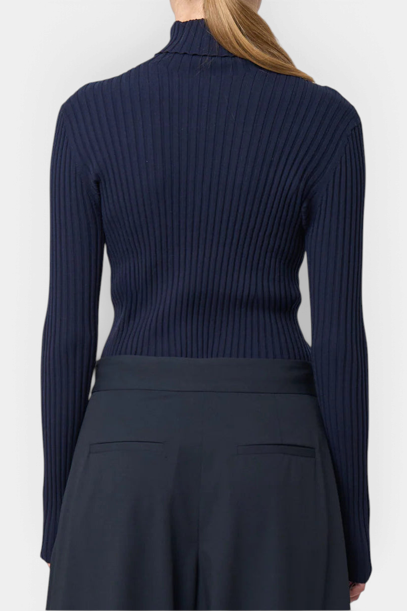 The Copper Shed Ivy navy blue ribbed turtleneck sweater with long sleeves worn from the back view