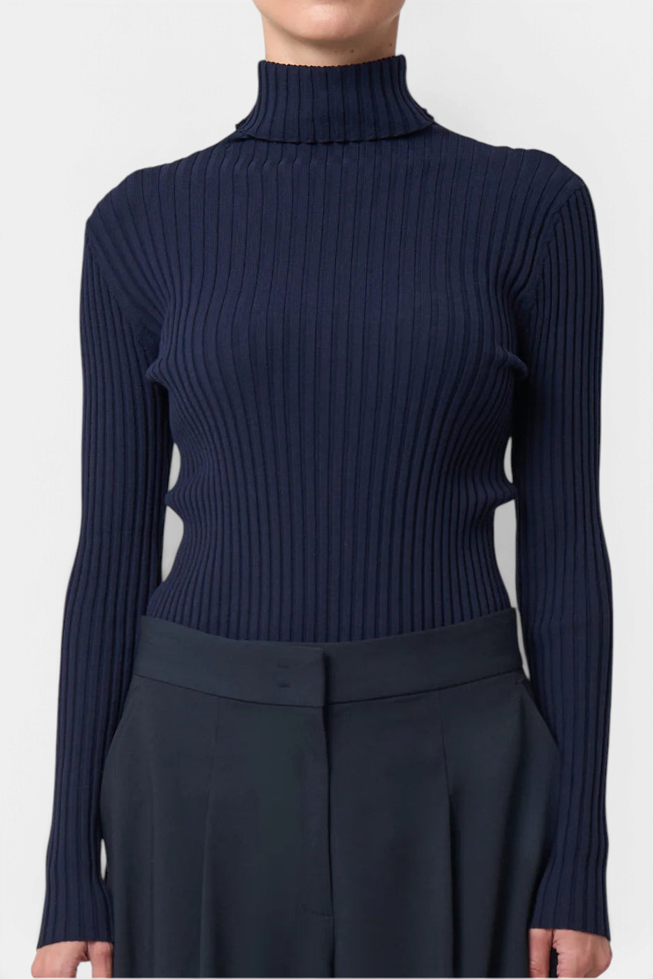 The Copper Shed Ivy ribbed turtleneck sweater in navy blue with long sleeves and a slim, body-hugging fit.