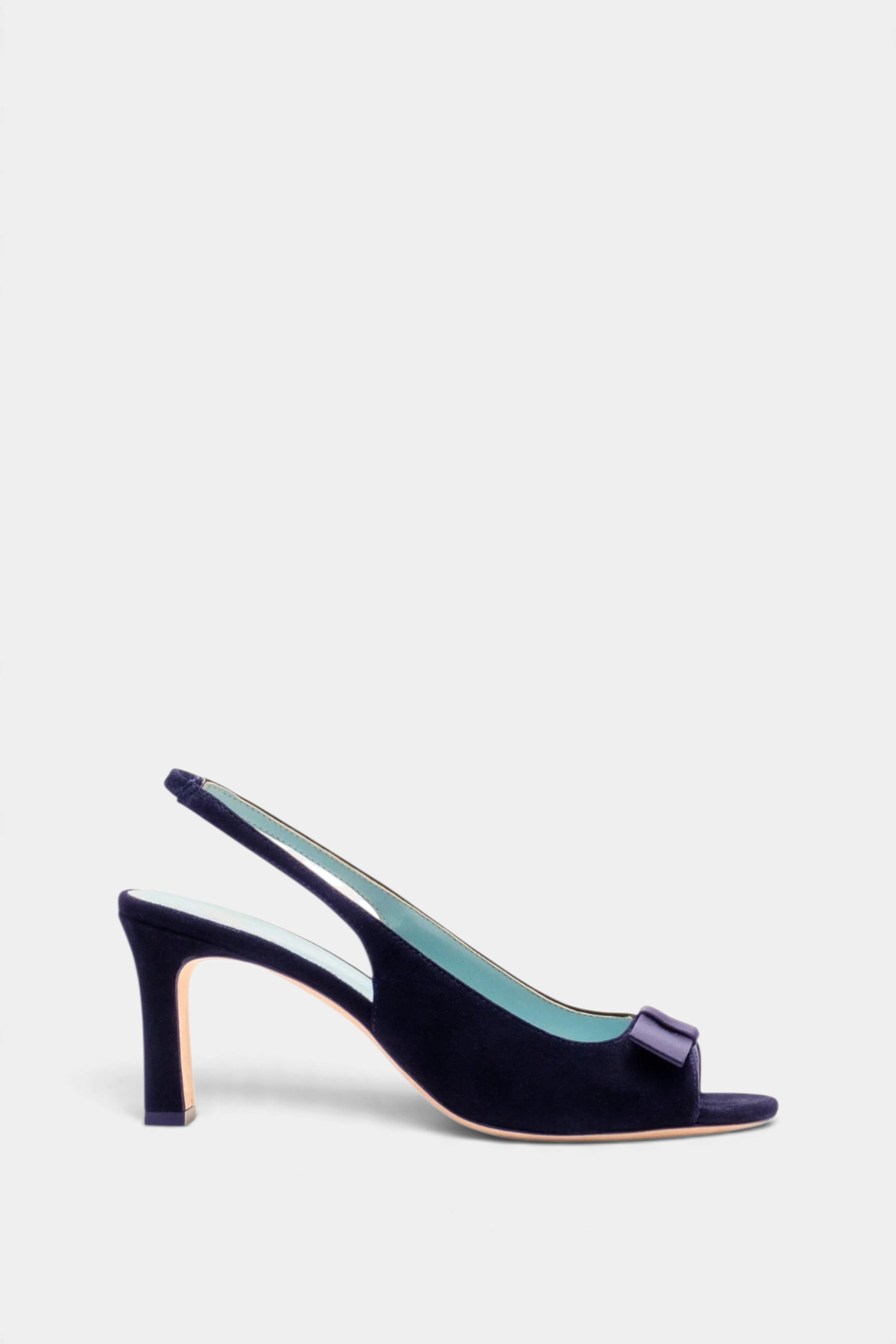 The Copper Shed navy suede Reese slingback heel with an open toe, ankle strap, and elegant bow detail on the vamp.