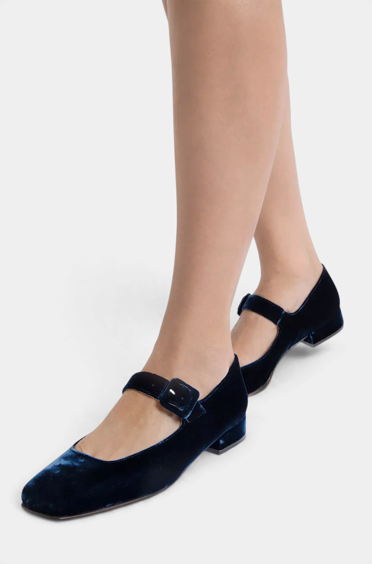 The Copper Shed navy blue velvet Mary Jane shoes with a low heel and buckle strap worn on a model