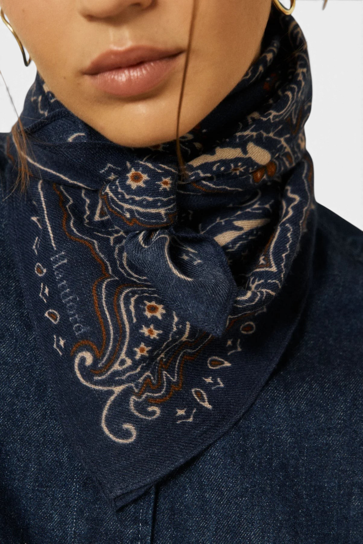 The Copper Shed navy blue wool bandana with a detailed paisley pattern worn tied around the neck