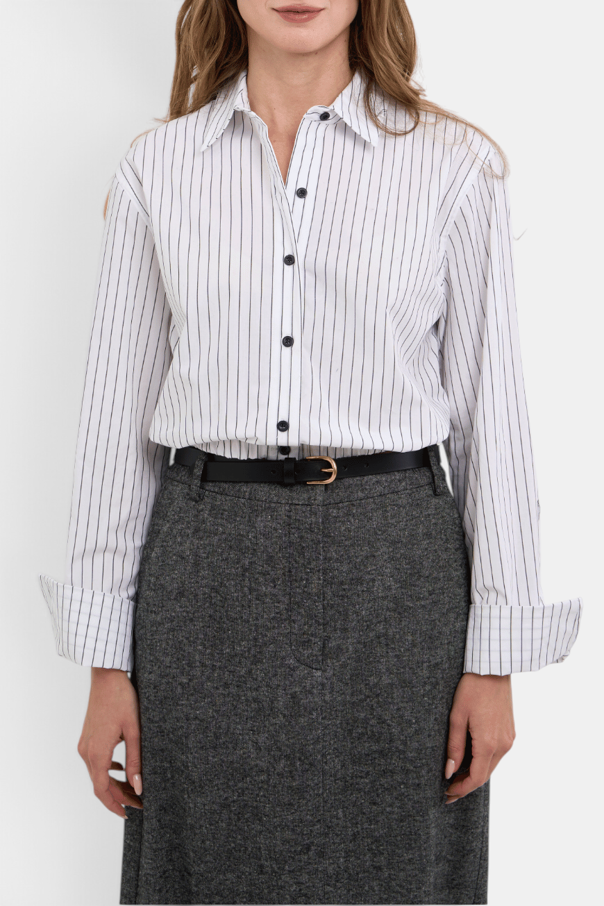 The Copper Shed Noa white cotton blouson shirt with black vertical stripes, button cuffs, and a collared neckline.