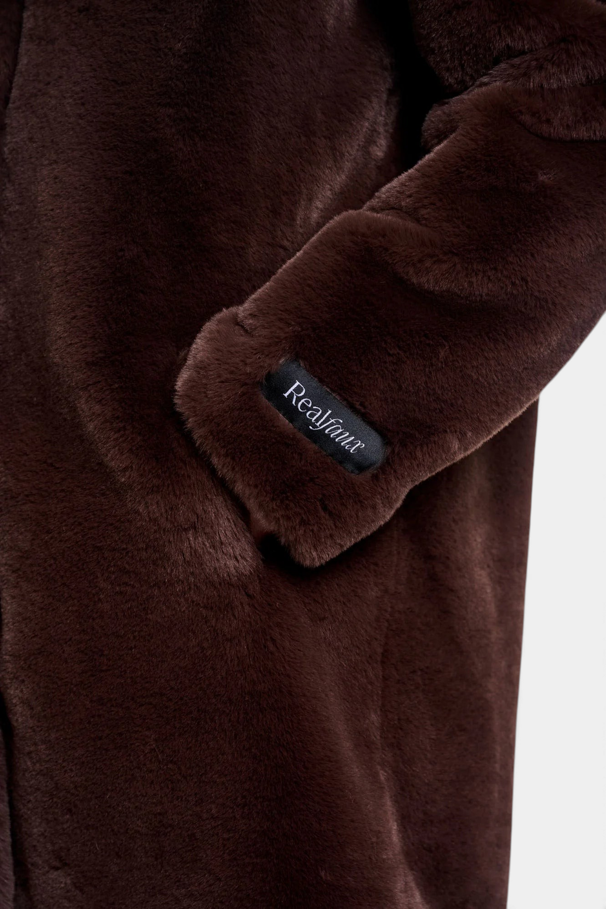 The Copper Shed Nonna coat in dark brown faux fur featuring a removable Real Faux sleeve label detail.