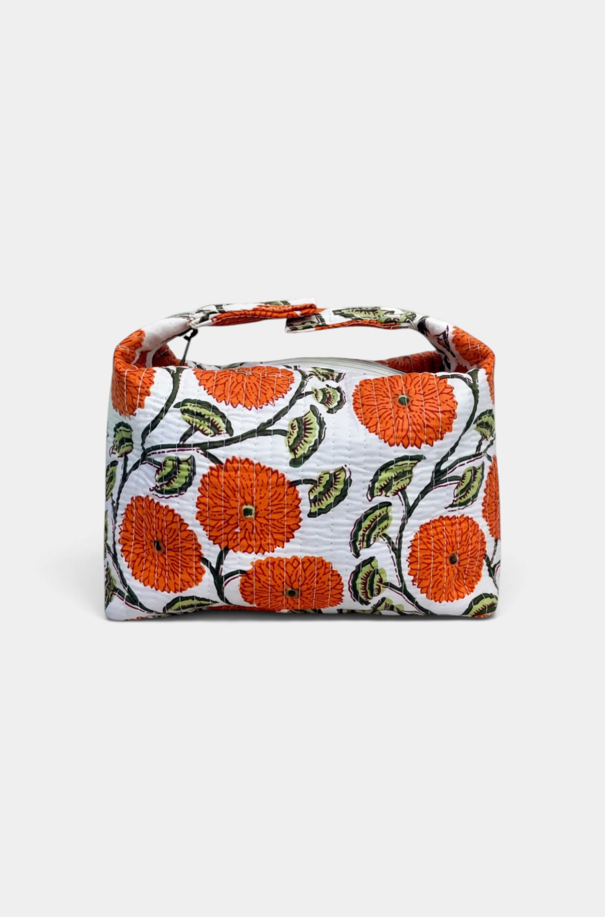 The Copper Shed orange floral block print quilted makeup bag with a zip closure and adjustable snap strap.