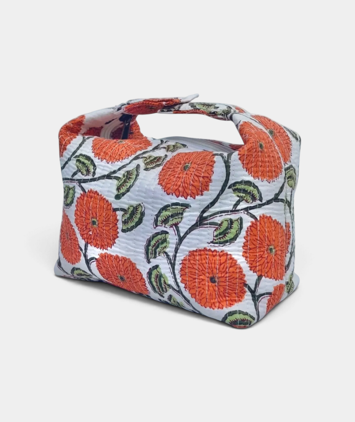 The Copper Shed quilted makeup bag in white with orange floral Indian block print and adjustable snap strap.