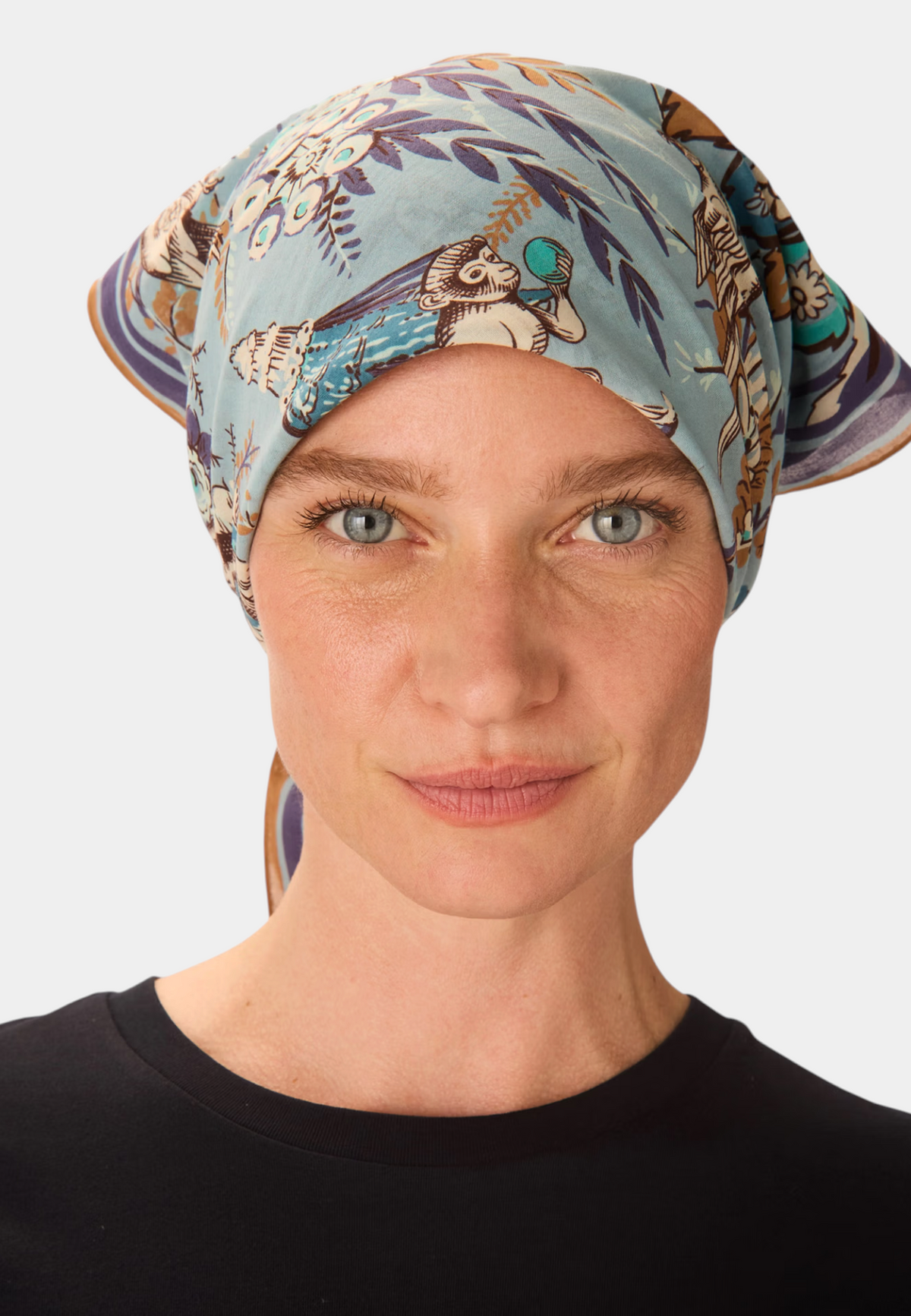 The Copper Shed Square 70 Pagode cotton scarf in blue worn as a headscarf by a woman