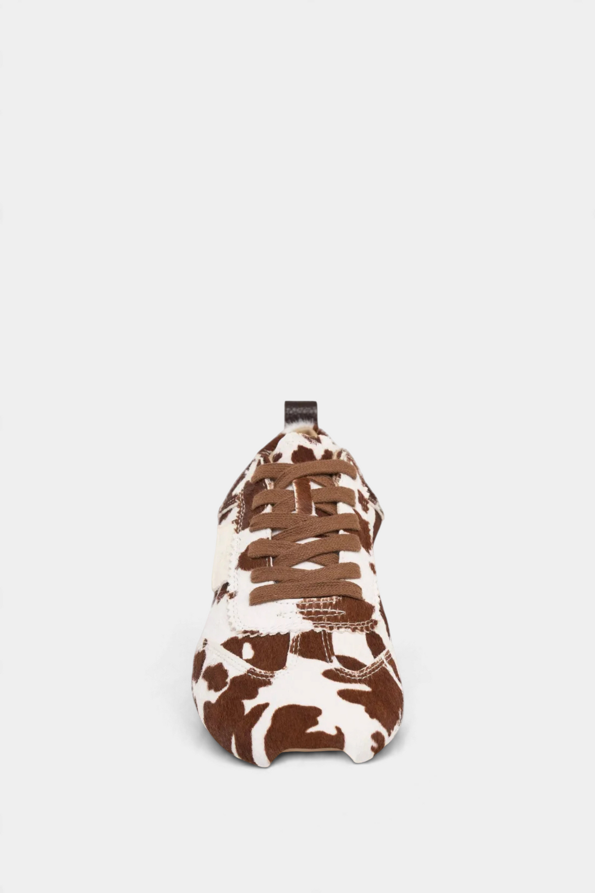 The Copper Shed Paige leather sneaker featuring a brown and white cow print pattern with brown laces, front view.