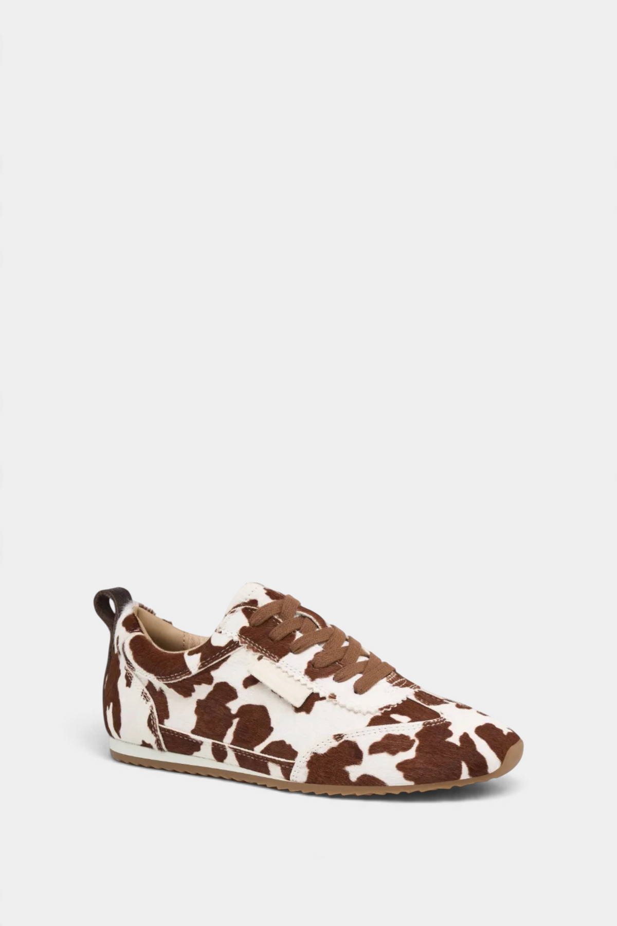 The Copper Shed Paige leather sneaker featuring a brown and white cow print pattern with brown laces and a flat sole.