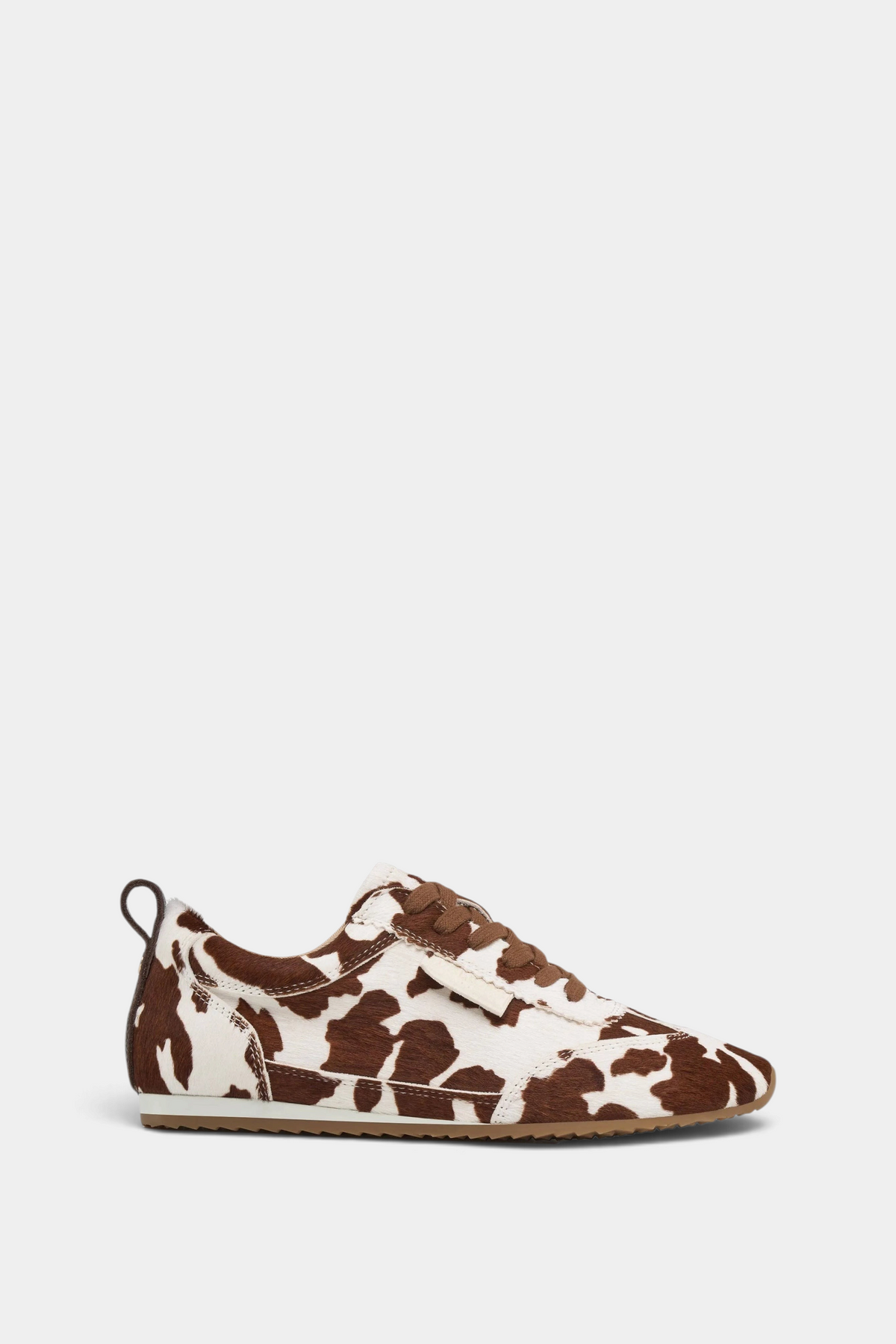 The Copper Shed Paige leather sneaker in a brown and white cow print pattern with a low-profile lace-up design.