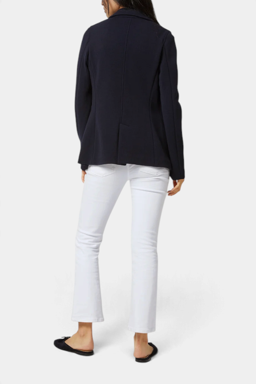 The Copper Shed Parker Jacket in navy wool pique, shown from the back paired with white jeans and black flats.