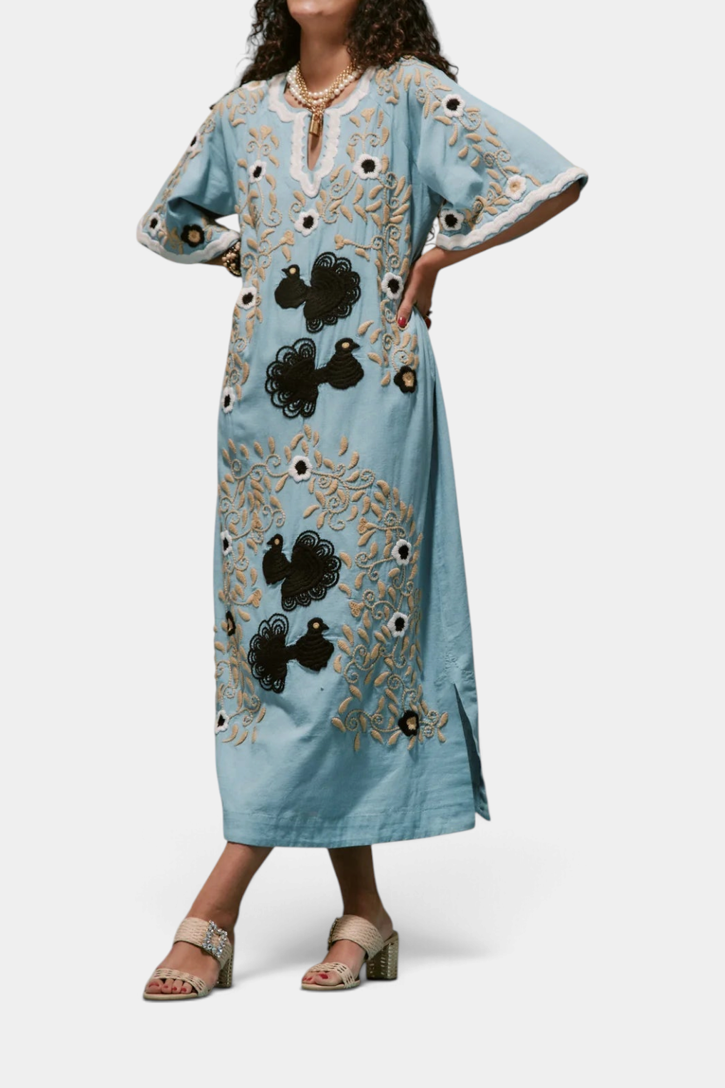 The Copper Shed light blue cotton maxi caftan with black and cream peacock embroidery, bell sleeves, and side slits.