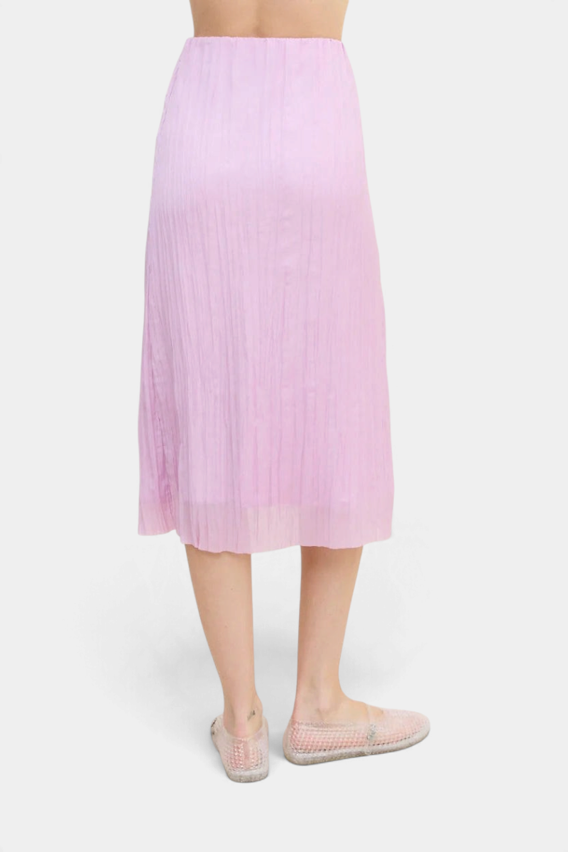 The Copper Shed Sabi midi skirt in light pink with crinkle-pleated texture and an elastic waistband.