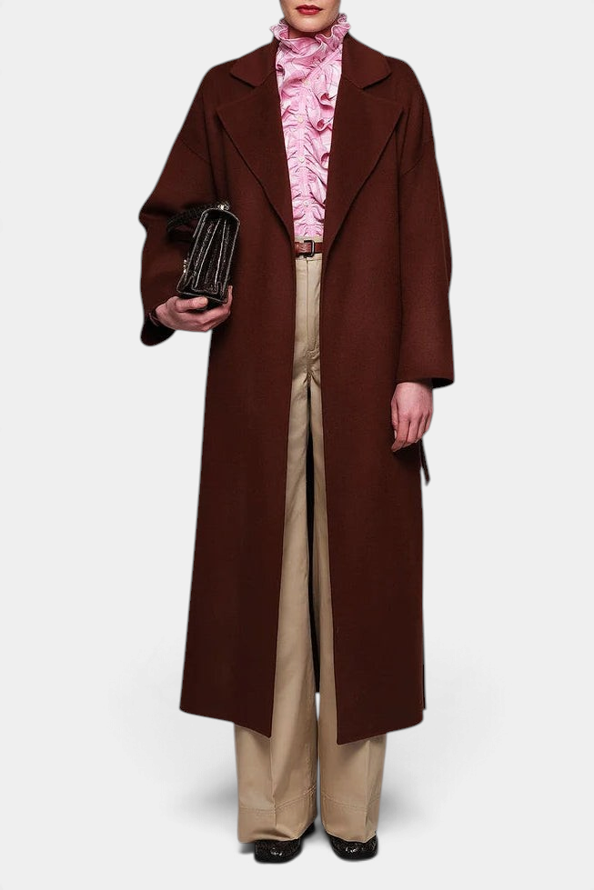 The Copper Shed pink plaid cotton flannel shirt with a removable ruffle collar worn under a long brown coat